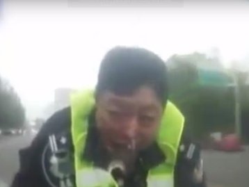 Tente não rir: policial chinês é arrastado por 2 km no capô de um carro