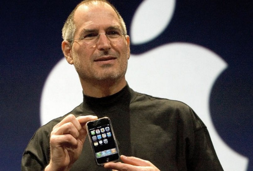 Steve Jobs segurando telefone.