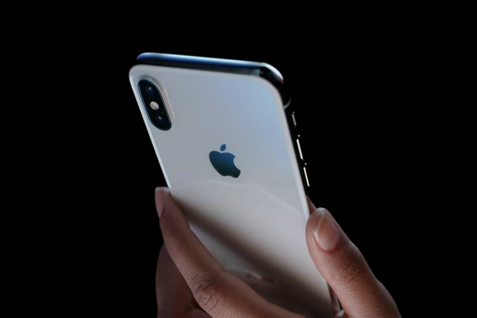 Uma mão segurando um iPhone X