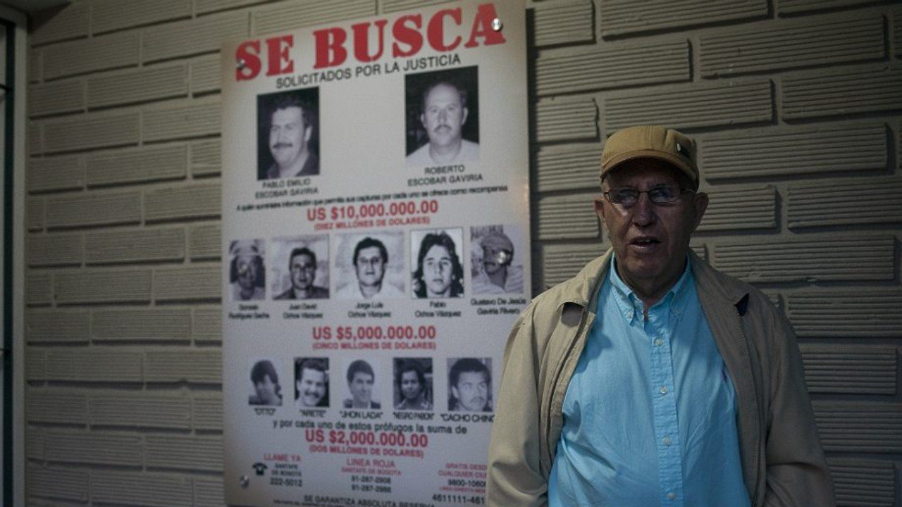 Roberto Escobar ao lado de um antigo cartaz de busca