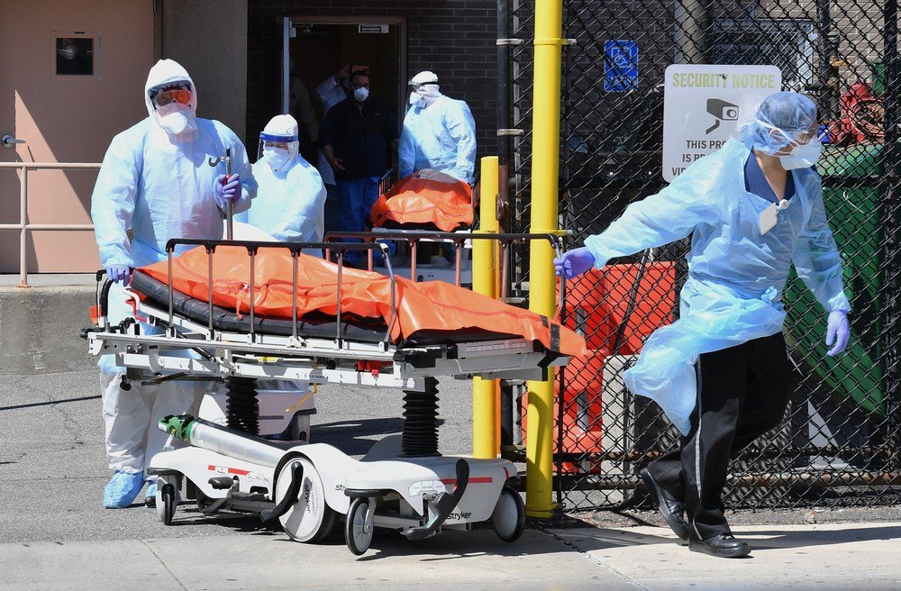 Médicos do Wyckoff Heights Medical Center, em Nova York, levam corpos de vítimas da covid-19 para um caminhão refrigerado, em abril deste ano.