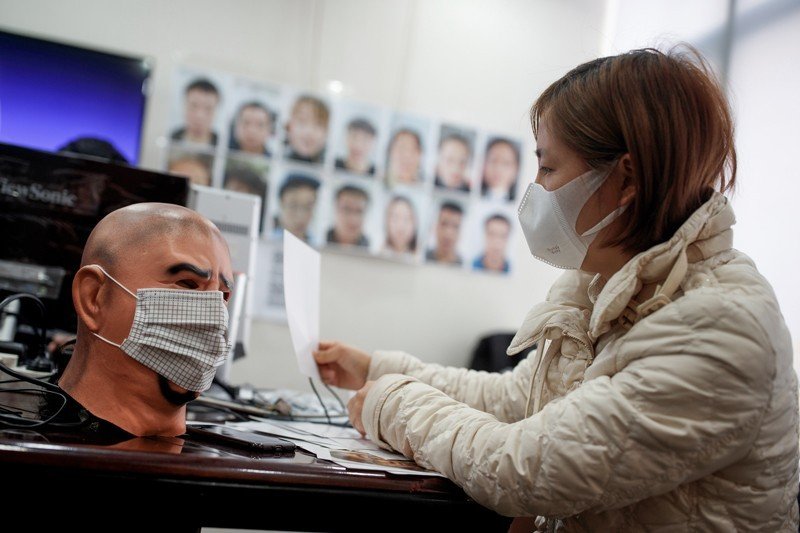 Uma engenheira de software testa um programa para identificar pessoas de máscara na empresa de tecnologia Hanwang, em Beijing.