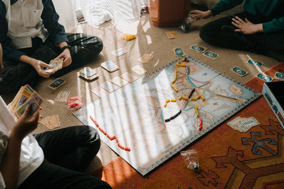 Pessoas alegres desfrutando de jogo de cartas com táticas e dados, jogando  jogos de tabuleiro junto com estratégia e cooperação. jovens amigos se  divertindo com o jogo, bebendo cerveja. fechar-se.