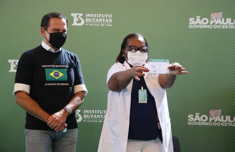 Mônica exibe o certificado de aplicação da primeira dose.