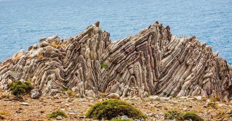 As dobras geológicas extremas de Agios Pavlos, na Grécia, mostram camadas de calcário originalmente depositadas nas profundezas do oceano,  e subiram à superfície juntamente com os Alpes.