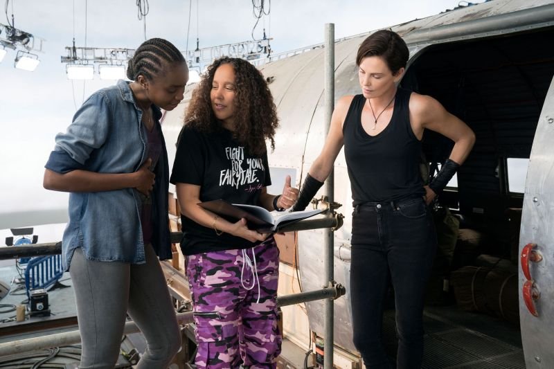 Diretora Gina Prince-Bythewood e as atrizes Kiki Layne e Charlize Theron no set de The Old Guard (2020).