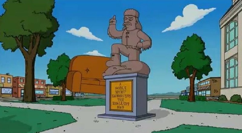 O lema da cidade de Springfield, com a palavra embiggens, fica exposto junto da estátua do fundador Jebediah Springfield. (Fox/Reprodução)
