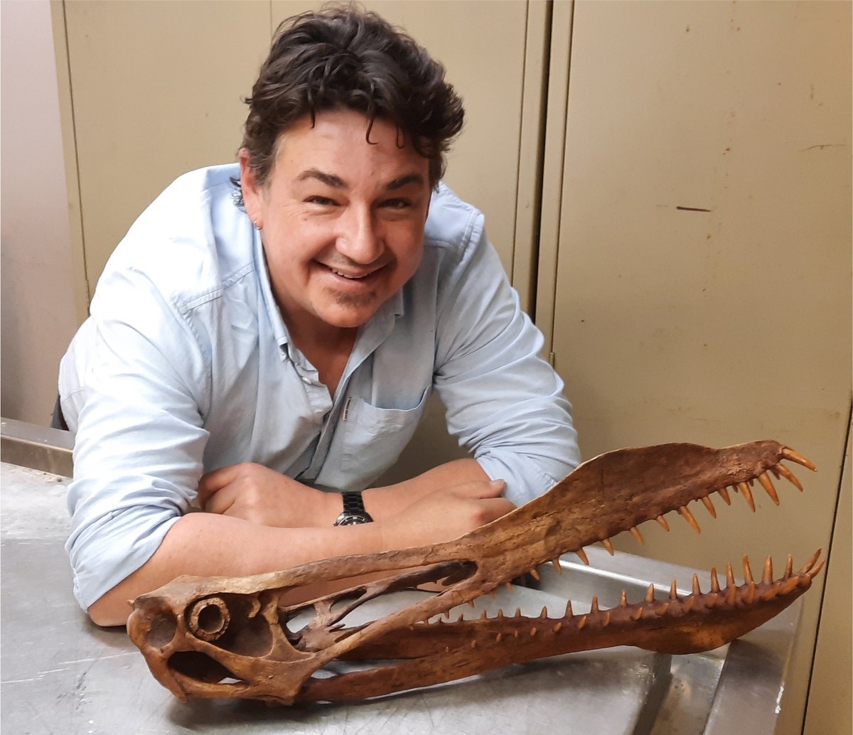 Tim Richards, autor do estudo, posa junto ao crânio de pterossauro.