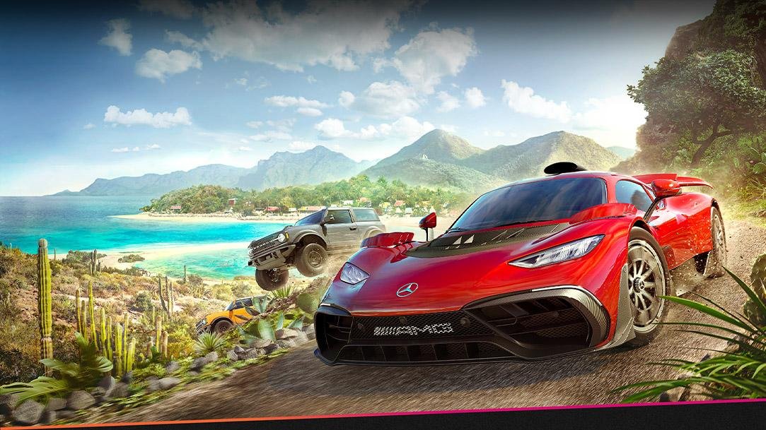 Descrição da imagem: Um carro esportivo vermelho passando ao lado de uma bela praia.