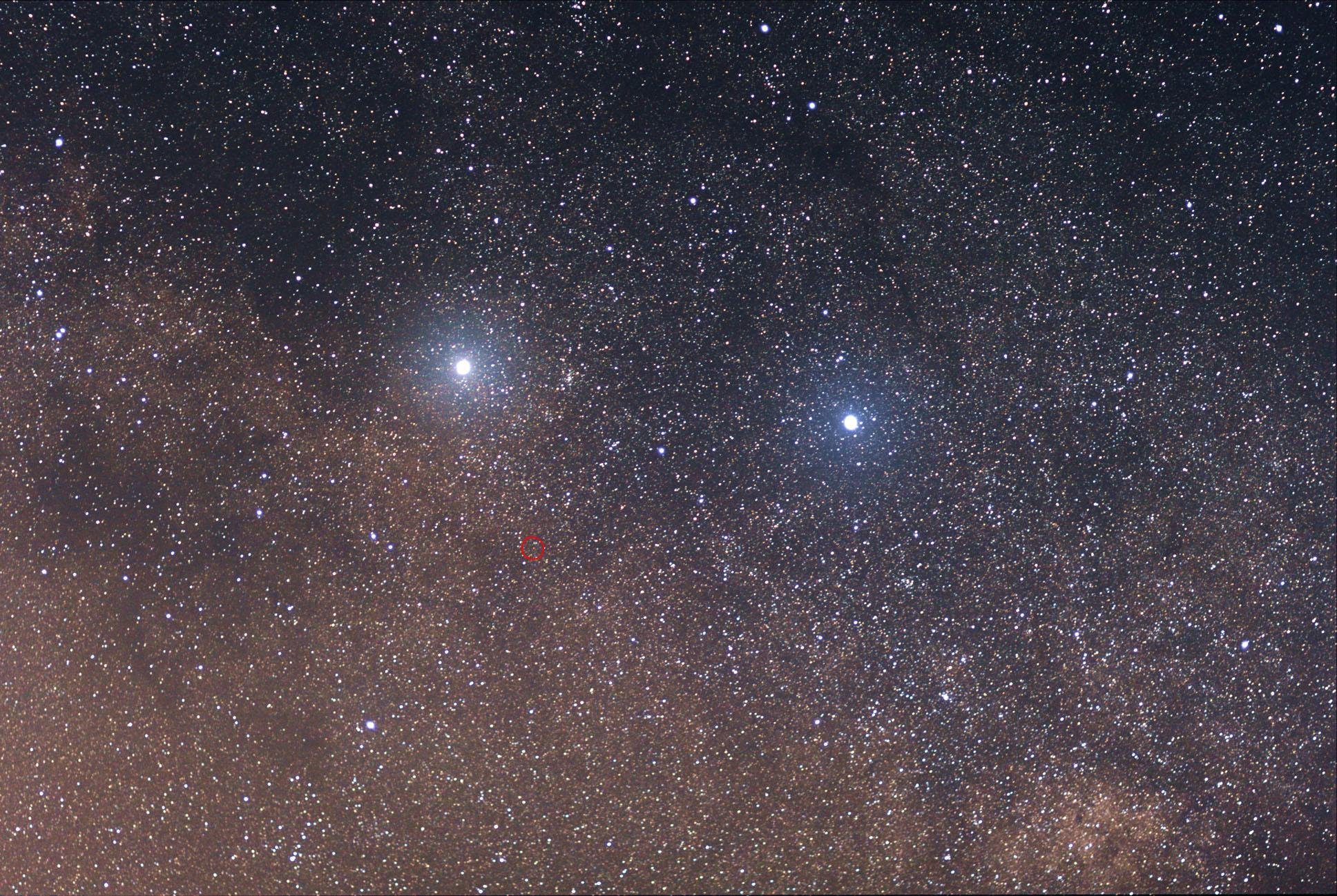 Sistema triplo Alpha Centauri. Podemos ver Alpha Centauri a (esquerda) e b (direita) claramente. A posição de Proxima Centauri está indicada pelo circulo vermelho. Por ser menor e menos brilhante, não é possível observá-la nessa imagem.