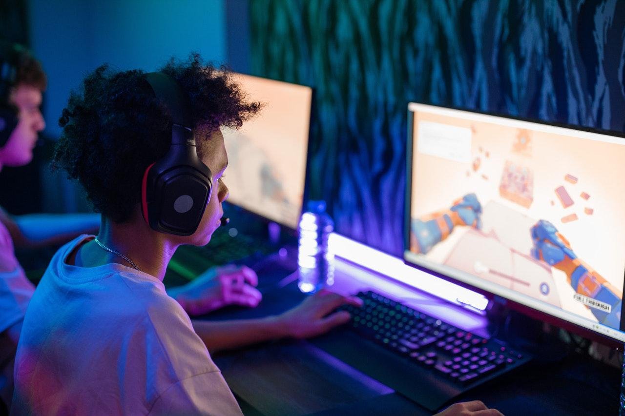 Um homem jogando um jogo na frente de uma tela de computador que diz 'game  boy