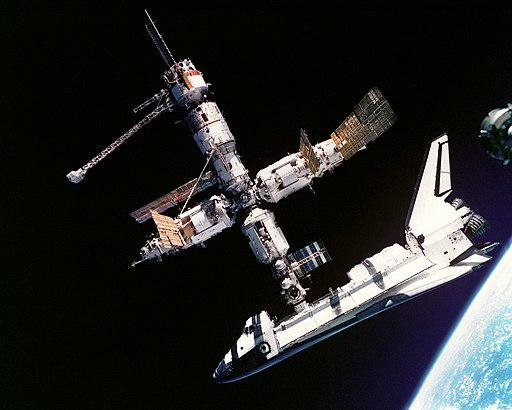 Ônibus espacial acoplado à estação russa Mir, primeira do mundo (Fonte: Wikimedia Commons/NASA)