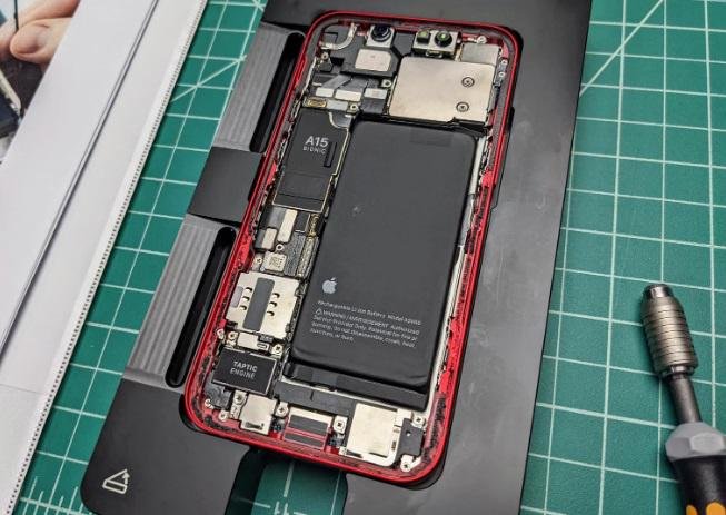 O celular aberto em uma das bandejas de molde e uma das ferramentas.
