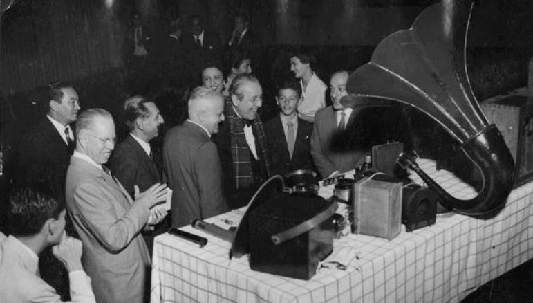 Em solenidade na Associação Brasileira de Televisão pelo 30º aniversário da implantação do rádio no Brasil, Roquette Pinto (de gravata borboleta) observa "antigos e modernos" aparelhos de radiofonia. (Agência O Globo)