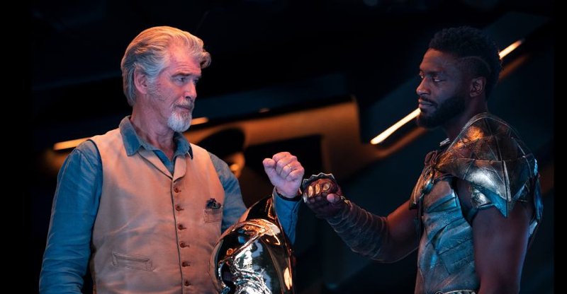 Pierce Brosnan e Aldis Hodge nos bastidores de 'Adão Negro'. (Fonte: IMDb)