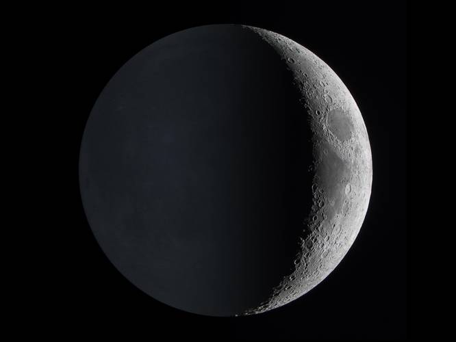 O brilho da Terra é visto refletindo no lado mais obscurecido da superfície lunar.