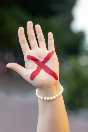 O sinal X vermelho na mão também é uma forma pedido de socorro contra violência doméstica.