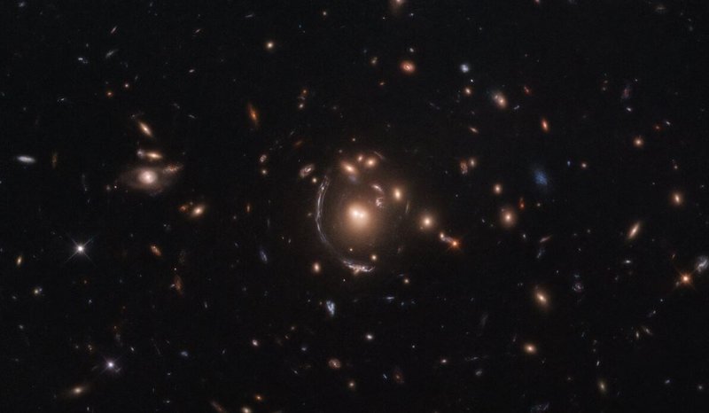 A imagem acima foi fotografada pelo Telescópio Espacial Hubble e apresenta uma distorção causada por lentes gravitacionais, um fenômeno previsto por Albert Einstein.