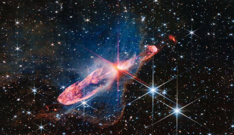 As estrelas que emitem jatos energéticos podem ser observadas no centro da imagem, próximo da área em branco e laranja.