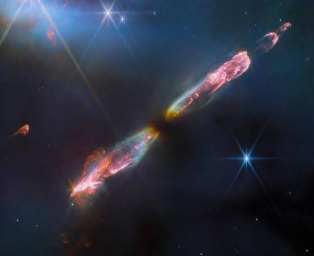 A observação de alta resolução e infravermelho próximo do Telescópio Espacial James Webb da NASA em Herbig-Haro 211 revela detalhes requintados do fluxo de uma estrela jovem, um análogo infantil do nosso Sol.