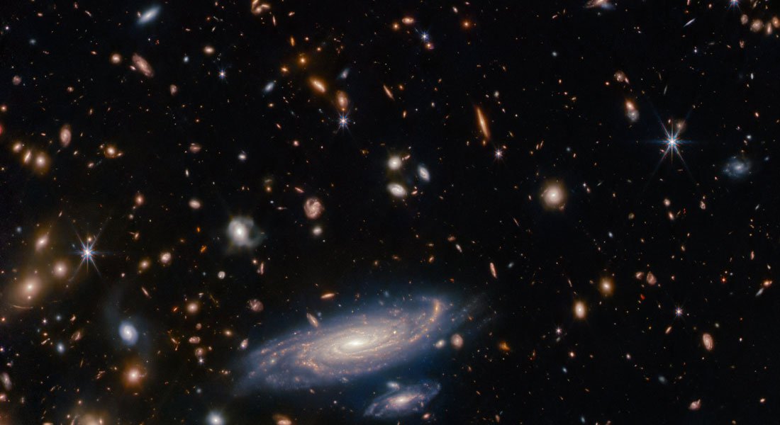 A grande galáxia em primeiro plano chama-se LEDA 2046648.