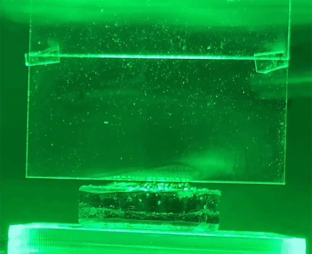Condensação branca no vidro à medida que a luz verde evapora o hidrogel.
