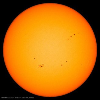 A solar disk containing multiple sunspots.