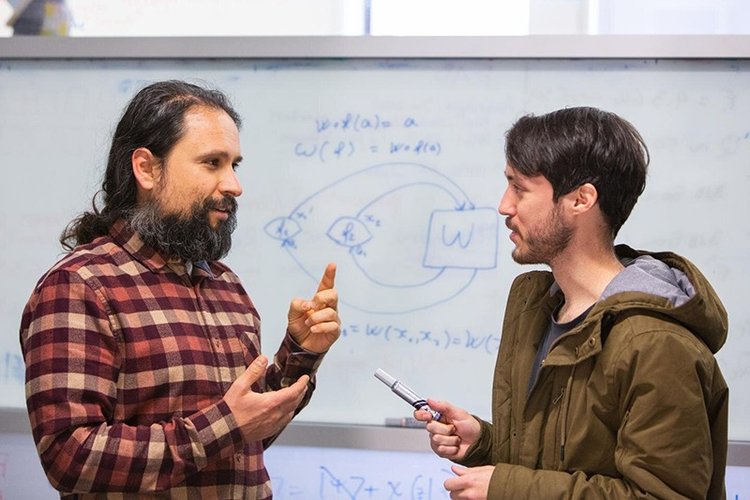 O professor de física da Universidade de Queensland, Fabio Costa, à esquerda, fala com o estudante de graduação em ciências Germain Tobar.