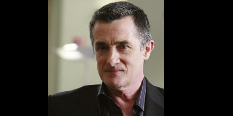 Roger Rees como Colin. 