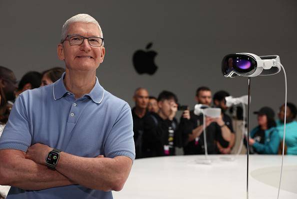 O CEO da Apple, Tim Cook, ao lado de um Vision Pro.
