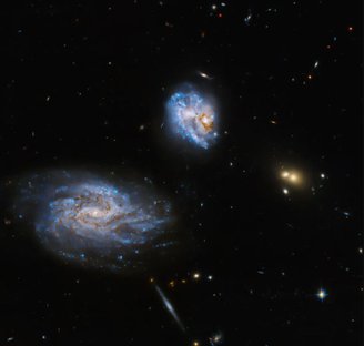 As galáxias UGC 05028 e UGC 05029 são apresentadas na parte central da imagem, bem como estrelas representadas pelas cores azuis. Há também outras cinco galáxias distantes de fundo na parte inferior da imagem. 