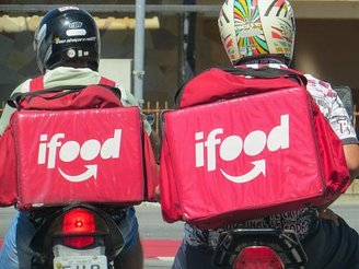 Dois entregadores do iFood, que ganham pela hora trabalhada.