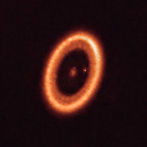 A imagem apresenta o sistema estelar infantil PDS 70 fotografado pelo Atacama Large Millimeter/submillimeter Array (ALMA).