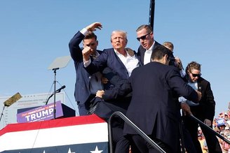 Donald Trump é protegido por seguranças após o atentado.