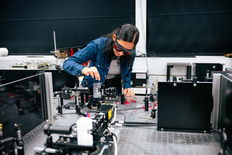 Doutoranda Eksha Chaudhary com a configuração de espectroscopia vibracional correlacionada.