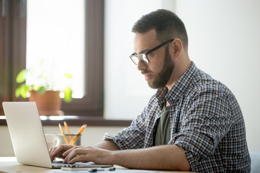 Homem trabalhando em um notebook em seu escritório.