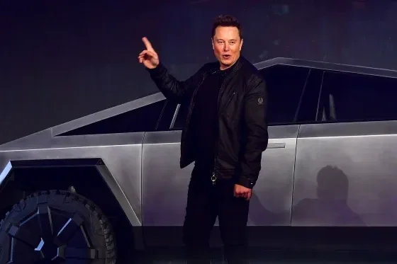 Elon Musk diante de um carro Tesla.