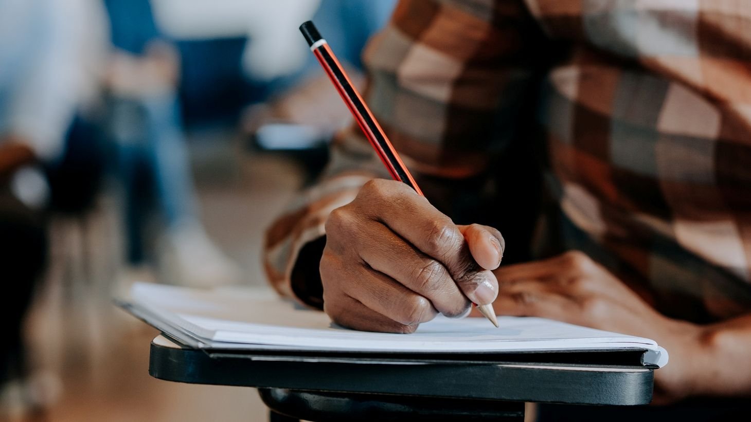 Foto de um estudante segurando um lápis