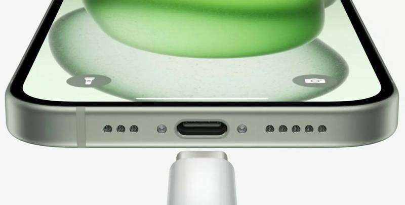 Um iPhone na cor branca visto de cima, com o conector USB-C sendo acoplado na parte traseira do aparelho.