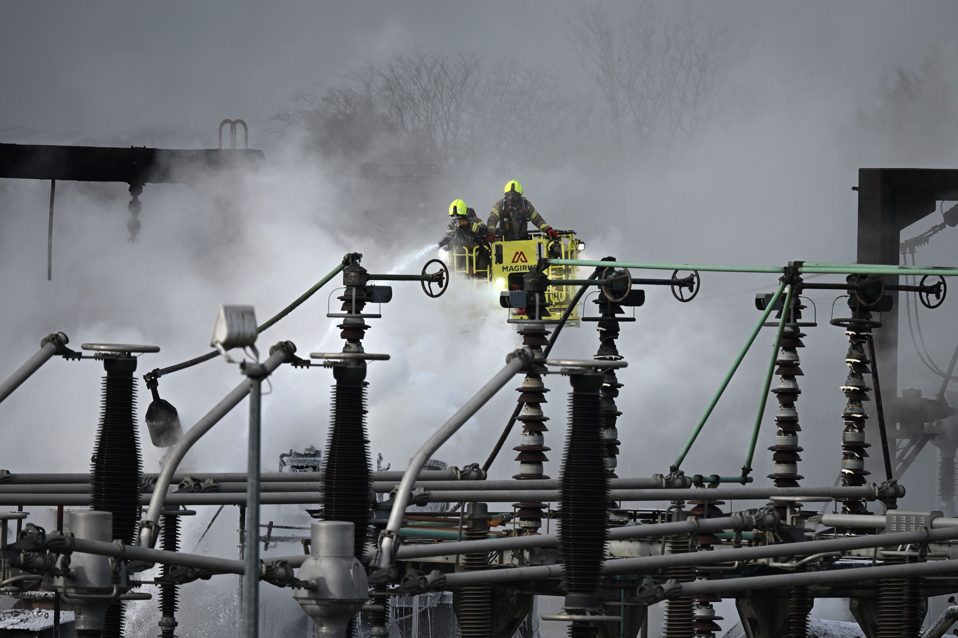 Foto de bombeiros apagando as chamas em estação de energia