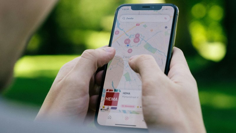 Foto de uma pessoa segurando um iPhone com Google Maps aberto