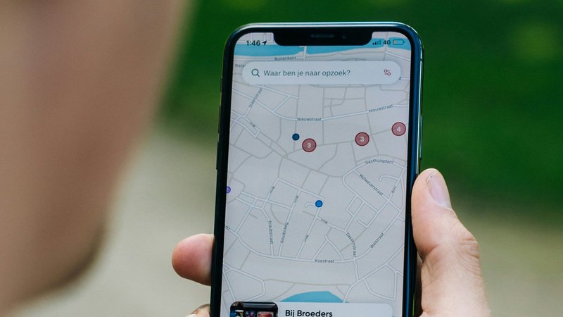 Foto de uma pessoa segurando um iPhone com o Google Maps