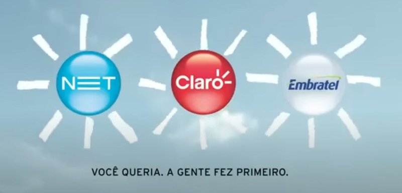 A logo de NET, Claro e Embratel com raios de sol desenhados ao redor, em um céu nublado.
