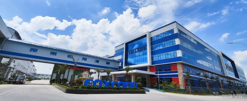uma fábrica da foxconn com janelas azuis e um anexo ligando dois prédios.