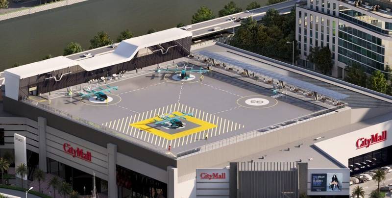 Uma área de embarque, pouso e decolagem de eVTOLs em cima de um shopping.