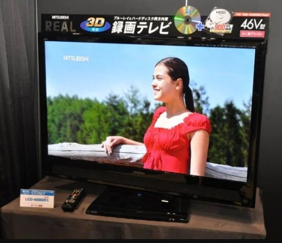 Um televisor da Mitsubishi exibido em cima de uma mesa de madeira.