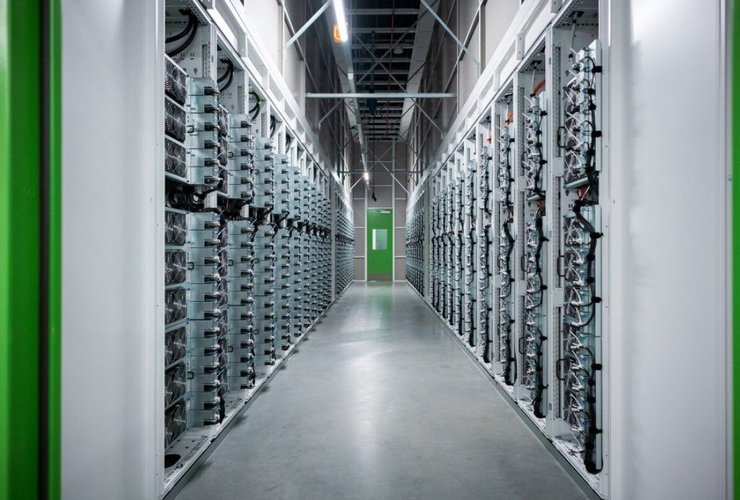 um corredor de um data center com vários servidores empilhados na vertical.