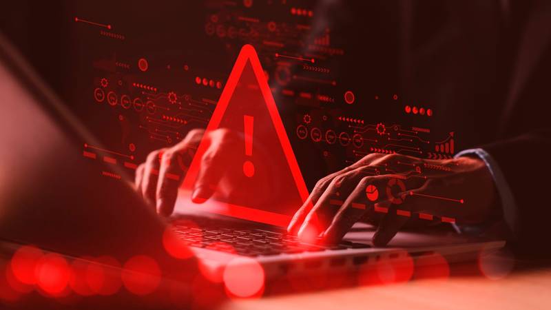 um computador sendo invadido, com vários sinais de alerta em vermelho