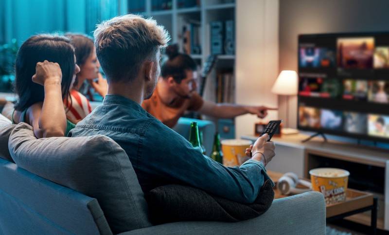 Amigos reunidos no sofá assistindo a um streaming