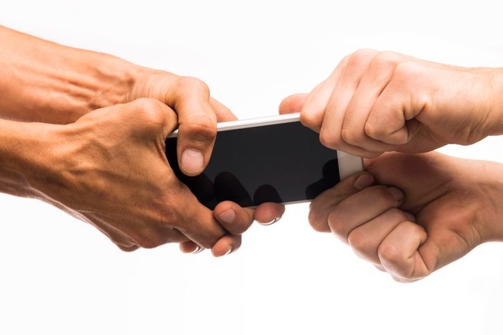 duas-maos-segurando-celular-de-um-lado-e-duas-maos-do-outro